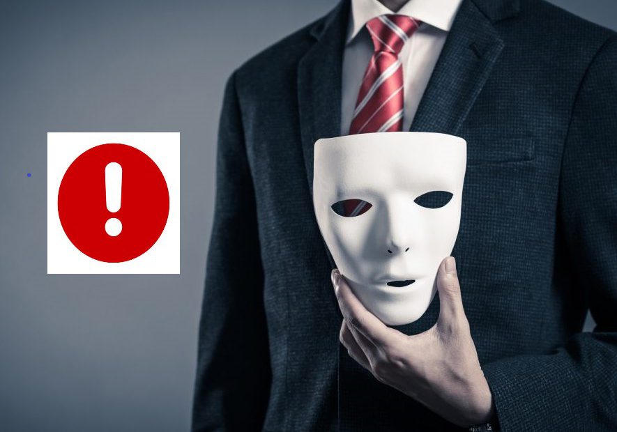 alt="Mężczyzna w garniturze trzymający białą maskę obok czerwonego znaku ostrzegawczego, symbolizujący demaskowanie oszusta matrymonialnego.