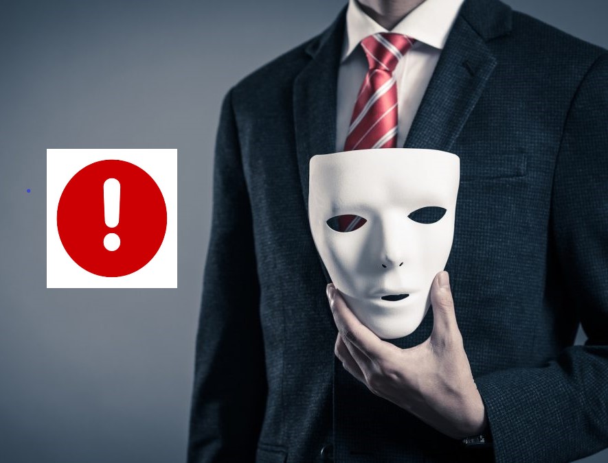 alt="Mężczyzna w garniturze trzymający białą maskę obok czerwonego znaku ostrzegawczego, symbolizujący demaskowanie oszusta matrymonialnego.